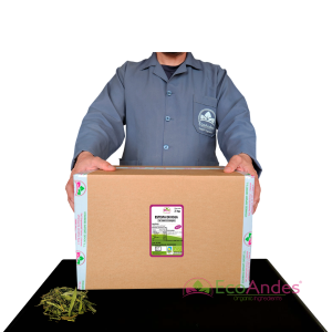 Persona con bata de laboratorio de la marca EcoAndes sosteniendo una caja de 3 kg de Estevia en hoja. El empaque muestra una etiqueta con información del producto, certificaciones ecológicas y sello de calidad y envasado artesanal.