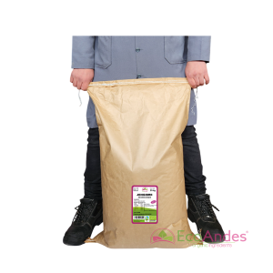 Persona con bata de laboratorio EcoAndes sosteniendo un saco grande de papel kraft de 25 kg de Jengibre en polvo. El empaque muestra una etiqueta detallada con certificaciones ecológicas y sello de producto orgánico.