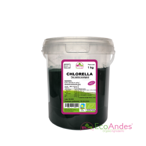 Cubo cilíndrico de 1kg de Chlorella en polvo de la marca EcoAndes. El envase es de papel kraft con ventana transparente que muestra el contenido, etiqueta frontal con información nutricional, certificaciones ecológicas, sin gluten y sello de "envasado artesanal".
