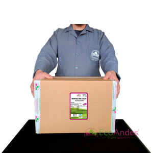 Persona con bata de laboratorio de la marca EcoAndes sosteniendo una caja de 15 kg de Manteca de cacao. El empaque muestra una etiqueta con información del producto, certificaciones ecológicas y sello de calidad y envasado artesanal.