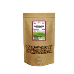 Bolsa de 1kg de Soja texturizada gruesa de la marca EcoAndes. El envase es de papel kraft con ventana transparente que muestra el contenido, etiqueta frontal con información nutricional, certificaciones ecológicas, sin gluten y sello de "envasado artesanal".